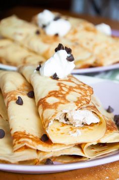 crepes with chocolate chips and whipped cream on top are served in white plates