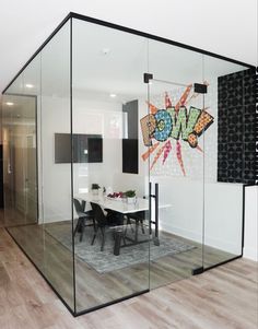 a glass walled room with a dining table and chairs