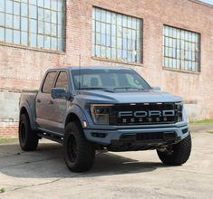 a gray truck parked in front of a brick building