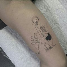 a person with a tattoo on their arm holding a flower in one hand and an object in the other