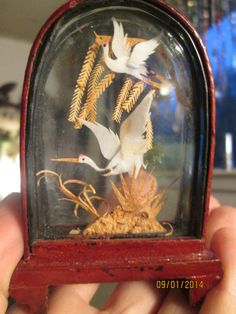 there is a miniature clock with birds in it