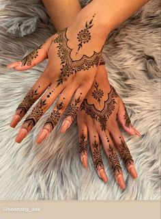 two hands with henna tattoos on them