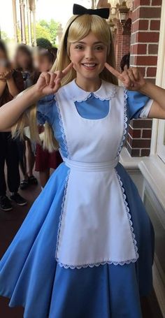 a woman in a blue and white dress posing for the camera