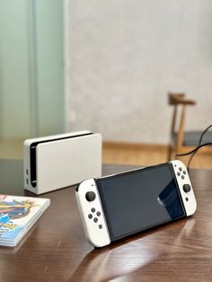 a nintendo wii game system sitting on top of a wooden table next to an ipod