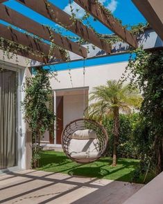 an outdoor area with a swing chair and potted plants