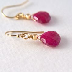 These Ruby earrings feature faceted teardrops accentuated with a smooth bead and dangling from elegant French ear wires.  Available in gold-filled and sterling silver. DETAILS: 💎The earrings measure 25mm x 10mm ( The stones are 10 x 10 mm) 💎Sterling silver or gold-filled chain and findings Please feel free to contact me if you have any questions. Please note: As I use natural stones, they may vary slightly in shade, shape, or size. Stones may contain natural inclusions FACTS ABOUT RUBY: ↦ It i Faceted 14k Gold Filled Jewelry For Wedding, Elegant Wire Wrapped Briolette Teardrop Earrings, Faceted Briolette 14k Gold Filled Jewelry, Gift Faceted Beads Dangle Teardrop Earrings, Gift Teardrop Dangle Earrings With Faceted Beads, Gift Dangle Teardrop Earrings With Faceted Beads, Elegant Faceted Pear-shaped Jewelry, Faceted Teardrop Dangle Earrings As Gift, Faceted Teardrop Dangle Earrings For Gift