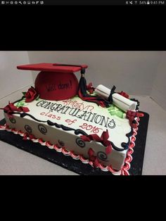 a graduation cake that is decorated with red and white icing on top of it