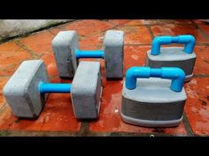 four cement blocks sitting on top of a red tile floor with blue piping attached to them