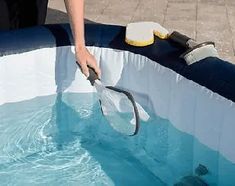 a man is cleaning the inside of an inflatable pool