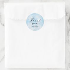 a white envelope with a thank you sticker on it