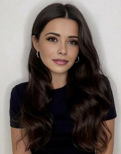 a woman with long brown hair wearing a black top