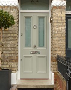 a grey front door on a brick house