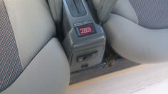 the interior of a car with an electronic device in the center console and seat belt