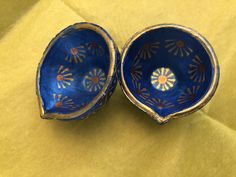 two blue bowls sitting on top of a yellow cloth