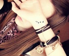 a woman wearing a bracelet with birds on her wrist and the word love written in black ink