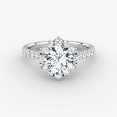 a white gold engagement ring with an oval cut diamond surrounded by pave set diamonds