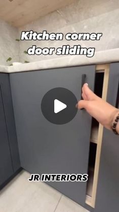 someone is opening the kitchen cabinet door and pointing at it with their thumbnails