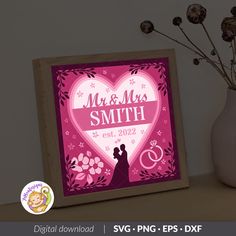 a wooden frame with a pink heart and wedding date on it