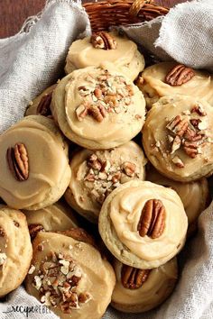 a basket filled with cookies covered in frosting and pecans on top of a table