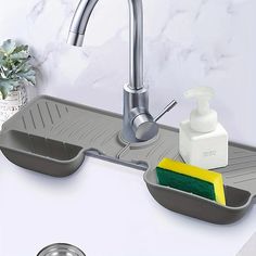 a kitchen sink with soap and sponge in it