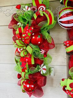 a red and green christmas wreath hanging on the side of a door with candy canes