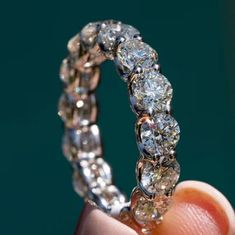 a close up of a person holding a ring with many diamonds on the inside of it