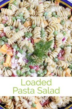 loaded pasta salad with peas and carrots in a blue bowl