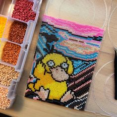 the bead art project is being worked on with scissors and thread, along with other beads