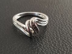 Sterling silver swirl ring with diamonds. The ring is a US size 6 3/4. It contains 12 diamonds at 0.005 cts for a total of 0.06 cts. The diamond has swirled middle and the diamonds are mounted to the right and left and to one part of the swirl. This will make a lovely gift for a special person as a promise, anniversary or friendship ring. Silver Bypass Ring With Diamond Accents For Gift, Silver Bypass Ring With Diamond Accents For Anniversary, Fine Jewelry Silver Bypass Ring With Diamond Accents, Silver Bypass Ring With Diamond Accents, Silver Bypass Ring With Diamond Accents For Formal Occasions, Formal Silver Bypass Ring With Diamond Accents, Friendship Ring, Friendship Rings, Swirl Ring