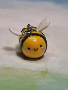 a yellow and black bee keychain sitting on top of a table