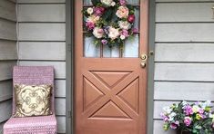 a pink chair sitting in front of a door with a wreath on it's side