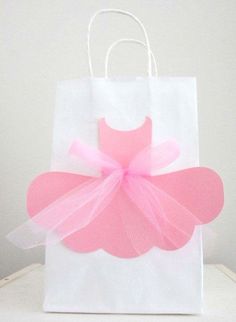 a pink and white bag with a bow on the front, sitting on a table