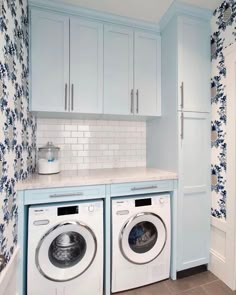 a washer and dryer in a small room with blue wallpaper on the walls