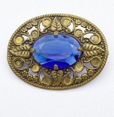 an antique brooch with a blue stone in the center