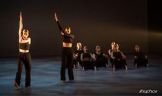 dancers in black and white pose for the camera with their arms up to the side