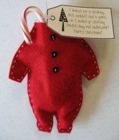 a red teddy bear keychain hanging from a hook with a tag attached to it