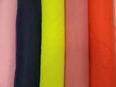 many different colors of fabric are lined up together in a row on the table top