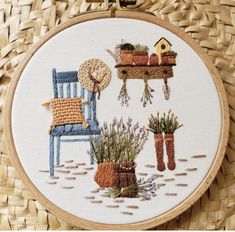 the embroidery is on and it has some plants in pots next to a blue chair