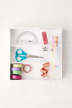 an organized drawer with scissors, tape and other office supplies