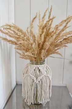 a vase filled with dried grass on top of a table