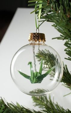 a glass ornament with an ornament hanging from it's side