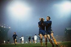 two soccer players are hugging each other on the field