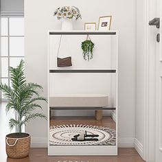 a white shelf with plants and pictures on it