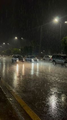 cars are parked on the side of the road in the rain as it rains at night