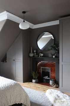 a bedroom with a fireplace and mirror above it