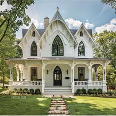 a large white house with black windows on the front and side porchs is surrounded by lush green grass