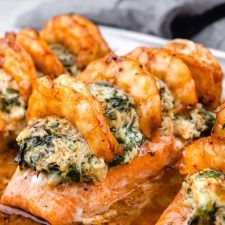 a white plate topped with meat covered in spinach