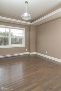 an empty room with hard wood flooring and white trim on the windowsills