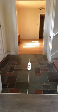 an open door leading to a hallway with a clock on the floor