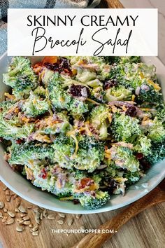 a white bowl filled with broccoli salad on top of a wooden cutting board